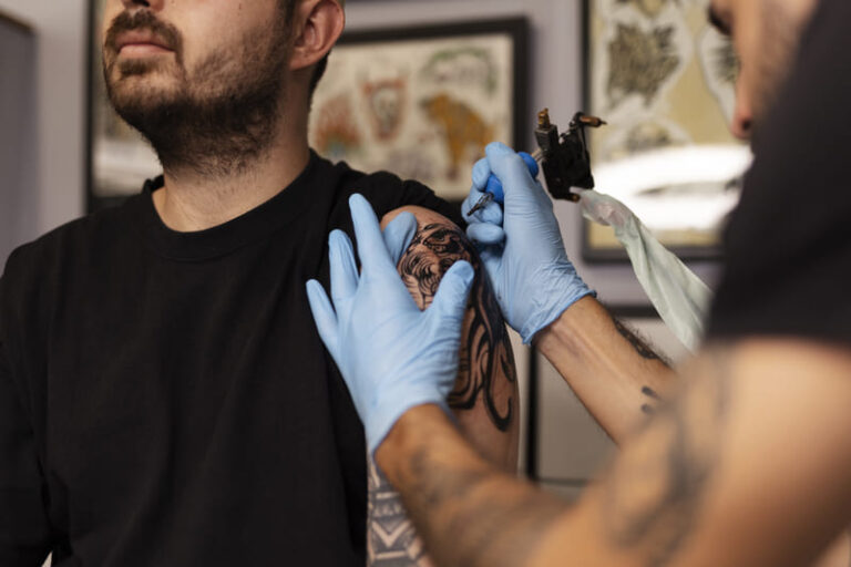 homem tatuando com luvas